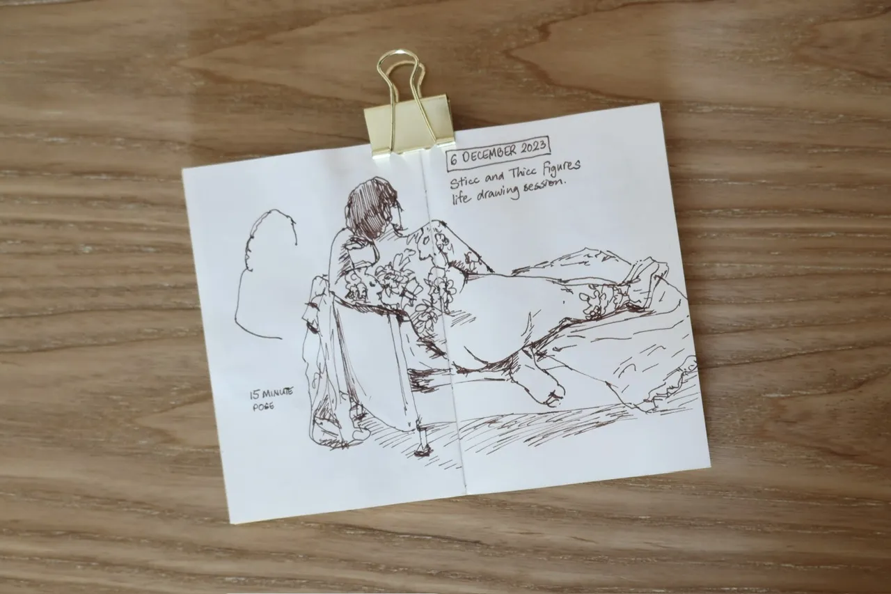 ink sketch of a nude tattooed woman reclining on a couch