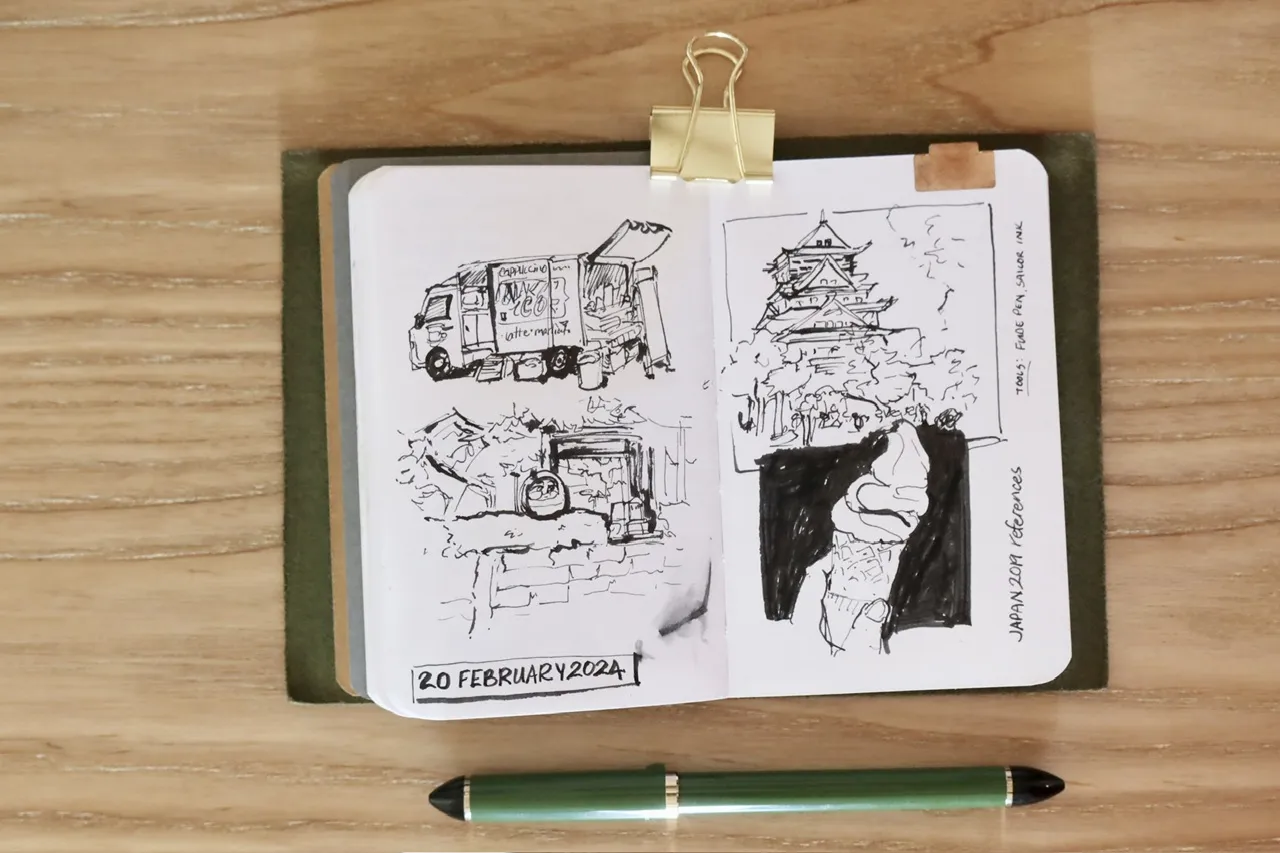 photo of a sketchbook with black and white sketches of scenes in Japan